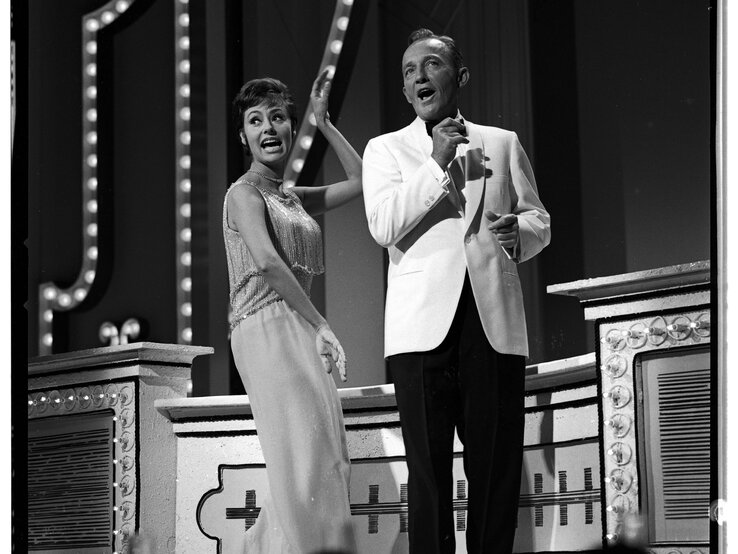 Caterina Valente und Bing Crosby, die gemeinsam auf einer Bühne stehen und offenbar singen. | © Getty Images/ABC Photo Archives / Kontributor