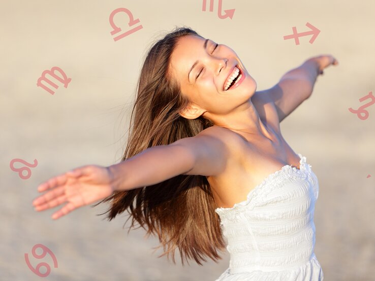 Eine glückliche Frau am Strand ist umgeben von den astrologischen Symbolen des Tierkreiszeichens.