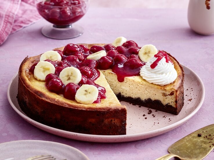 KiBa-Cheesecake auf einem rosa-farbenen Teller auf rosa Hintergrund. 